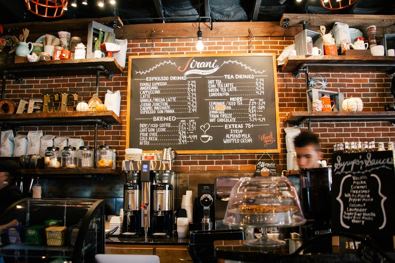 estantes de una cafetería con una barra y una persona que atiende. 